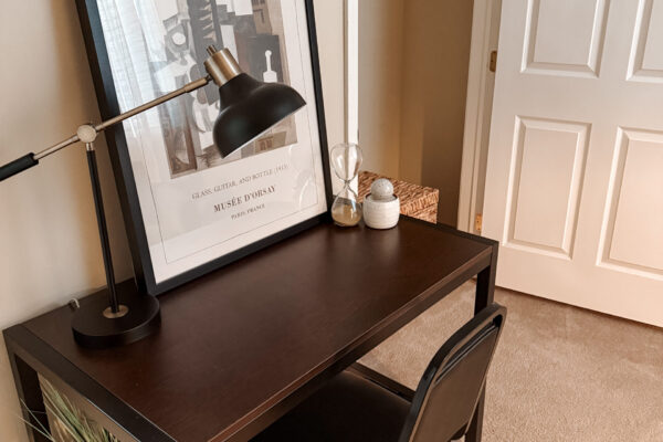 We offer fully furnished housing units Desk with the table light and a Pablo Picasso artwork on the table